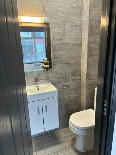 a bathroom with a toilet and a sink at Southall Edge Inn in Southall