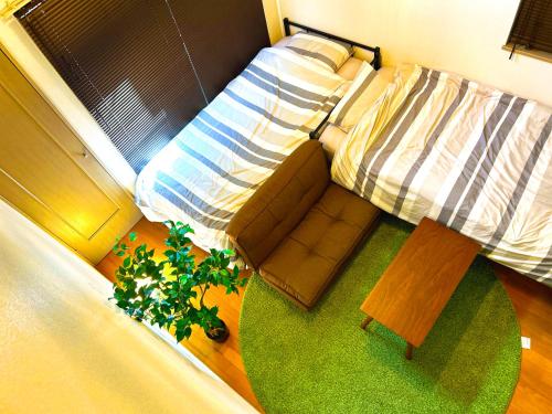 a bedroom with a bed and a chair and a table at 竹下 inn, Near the airport in Fukuoka