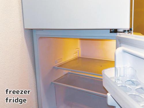 an empty refrigerator with its door open in a kitchen at 竹下 inn, Near the airport in Fukuoka