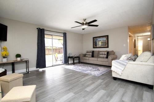 a living room with a couch and a ceiling fan at Entire Magill House by RiverPark in Fresno