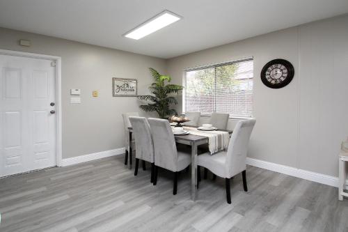 a dining room with a table and chairs and a clock at Entire Magill House by RiverPark in Fresno