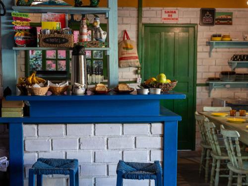a blue table with baskets of food on top at CasaHostel Floresce in Praia do Rosa