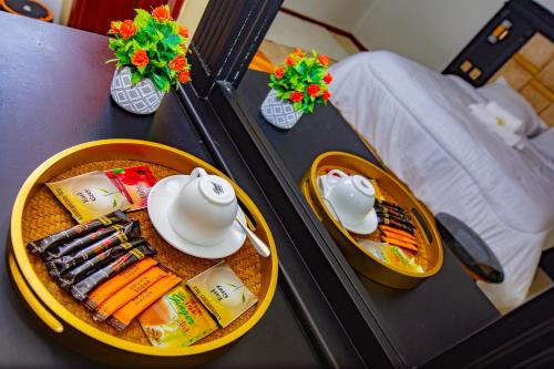 een tafel met een bord met eten en servies erop bij Divine Royal Residences in Arusha