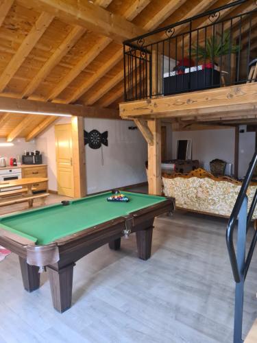 un salon avec un billard et une mezzanine dans l'établissement Appartement luxueux seez, à Séez