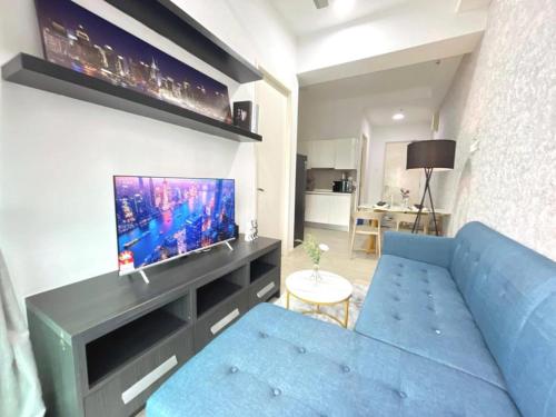 a living room with a blue couch and a tv at PJ 2 Room ID home design 1-8 pax 5 min to One U in Petaling Jaya