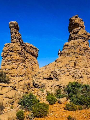 a man standing on top of a rock formation at tifrit maison d'hôtes-Paradise valley in Imouzzer des Ida Ou Tanane