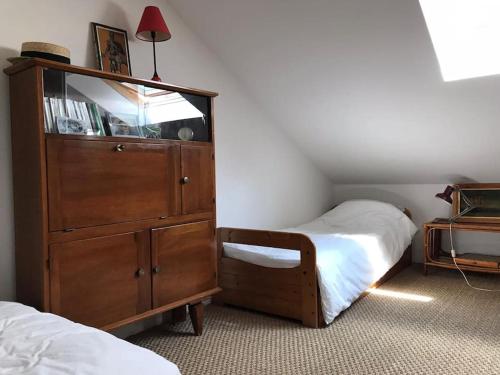 - une chambre avec une grande commode en bois et un lit dans l'établissement Petite maison cosy, à Pornic