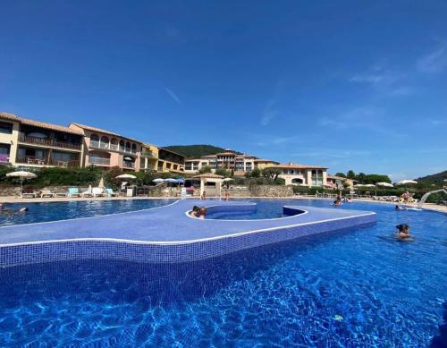 une grande piscine avec des gens dans l'eau dans l'établissement Studio vue mer, à Roquebrune-sur Argens