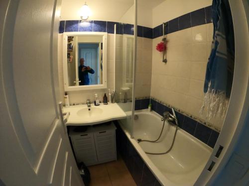 un homme prenant une photo d'une salle de bains avec baignoire et lavabo dans l'établissement Studio vue mer, à Roquebrune-sur Argens