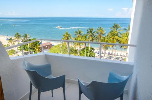 サンタ・マルタにあるHotel Be La Sierraの椅子とビーチの景色が見えるバルコニー