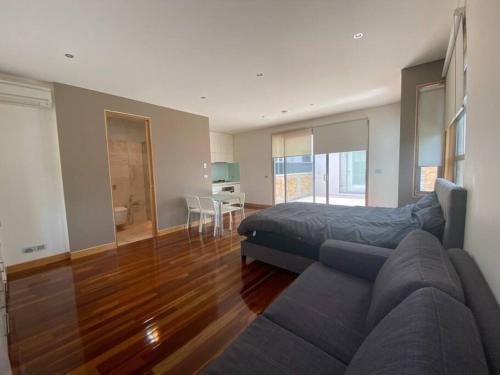 a living room with a couch and a bed at Entire studio with balcony in Melbourne
