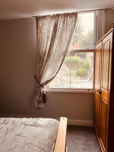 a bedroom with a bed and a window at Spacious 5 Bedroom Home in Central Kidderminster with Private Parking and Electric Vehicle Facilities, Easy Access to Birmingham and Nearby Towns in Kidderminster
