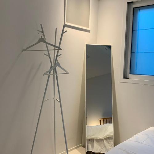 a tripod in front of a mirror in a bedroom at 정스테이 서울 잠실 롯데월드 kspodome 아산병원 길동 코엑스 성수명동강남동대문 in Seoul