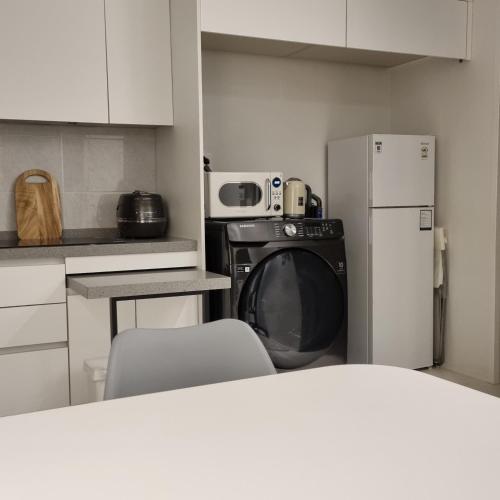 a kitchen with a refrigerator and a washing machine at 정스테이 서울 잠실 롯데월드 kspodome 아산병원 길동 코엑스 성수명동강남동대문 in Seoul