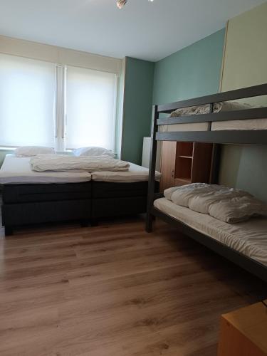 two bunk beds in a room with a window at De Zandhoorn in De Panne
