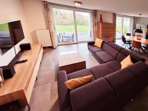 a living room with a couch and a television at Zwanebloem 2 in Cadzand