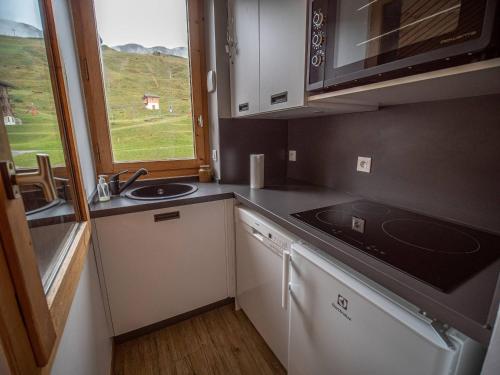 une petite cuisine avec un évier et une fenêtre dans l'établissement Spacieux 4P avec balcon, proche pistes et ESF, animaux admis - FR-1-356-255, à Valmorel