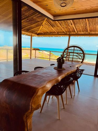 a wooden table in a room with a view of the ocean at Casa Amar Pipa in Pipa