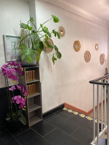 a room with a staircase with flowers and plants at Hôtel des Beaux Arts in Chambéry