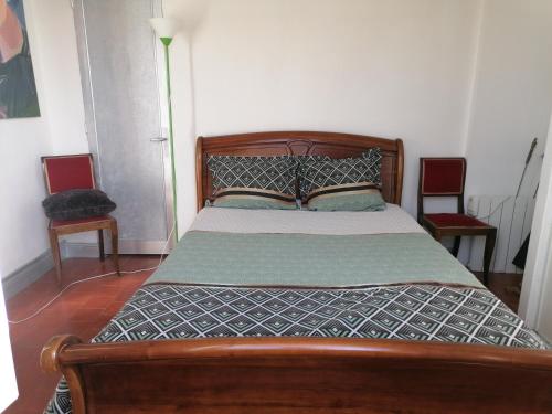 - un lit en bois dans une chambre avec 2 chaises dans l'établissement Maison sansonnette, à Guérigny