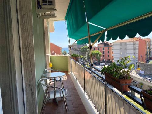a balcony with a table and chairs and an umbrella at Incantevole appartamento nel centro di Varazze in Varazze