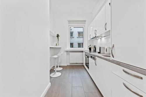 a white kitchen with a counter and a sink at Comfortable 2 Bedroom Apartment in Vienna