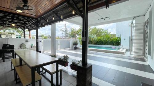 a living room with a table and a swimming pool at ANJUNG KASEH Villa Bukit Katil 4bedroom with Swimming Pool in Melaka