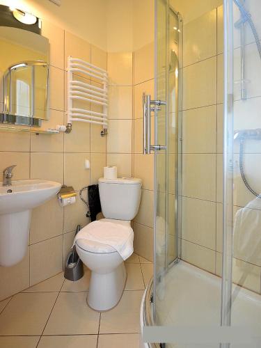 a bathroom with a toilet and a sink and a shower at Willa Atrium in Jantar