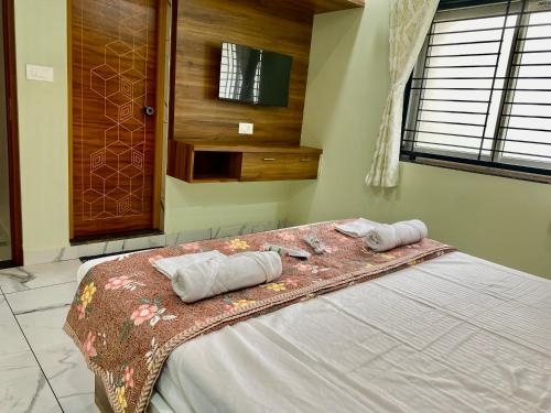 a bedroom with a bed with two towels on it at Arcadia Homestay in Kāsarkod