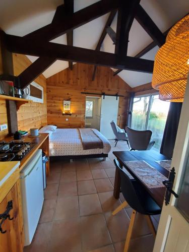 une chambre avec un lit et une cuisine dans une pièce dans l'établissement Cabane du lac, à Rouffignac-Saint-Cernin-de-Reilhac
