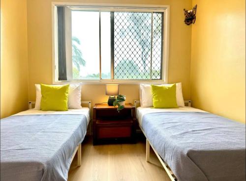 two twin beds in a room with a window at Heaven on Earth in Kingston