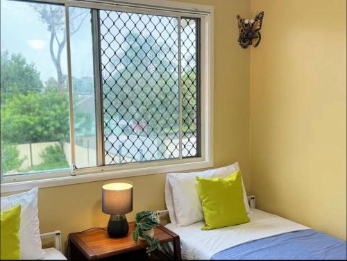 a bedroom with a window with a bed and a lamp at Heaven on Earth in Kingston