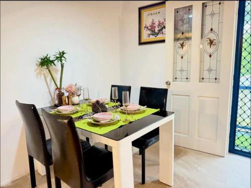 a dining room table with black chairs and a green table cloth at Heaven on Earth in Kingston