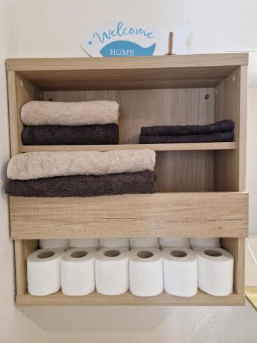 une étagère en bois avec du papier toilette et des serviettes dessus dans l'établissement Escale Romantique, à Strasbourg