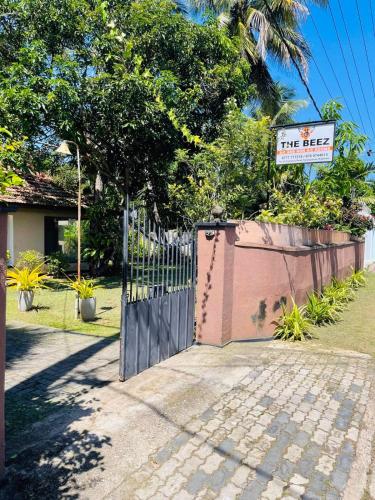 a gate with a fire exit sign in front of a house at The Beez in Negombo