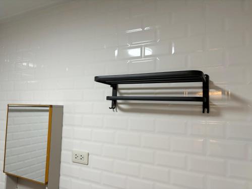 a black bench on a wall next to a mirror at Apamet Hotel Sukhumvit 55 in Khlong Toei