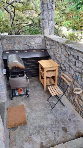a table and a chair next to a stone wall at Winter Breeze in Arachova
