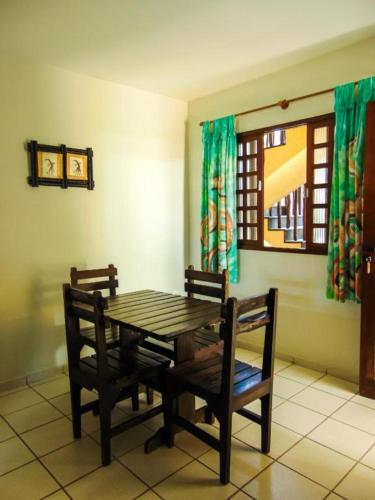 a dining room table with two chairs and a window at chales aguai in Natal