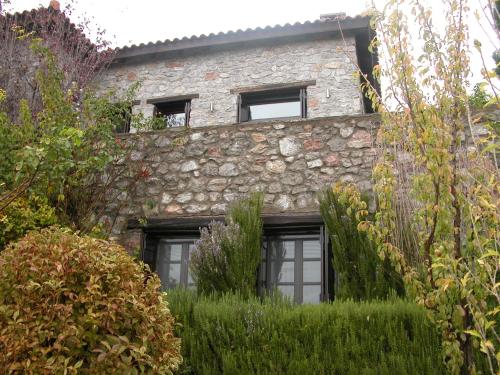 a stone building with windows and bushes in front of it at Winter Breeze in Arachova
