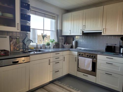 a kitchen with white cabinets and a sink and a window at Ferienwohnung Ott in Amelinghausen