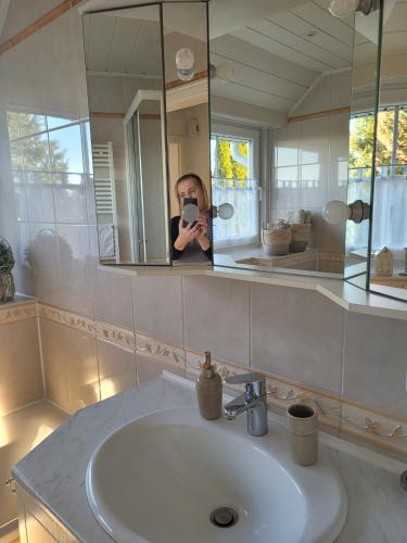 a person taking a picture of a bathroom sink at Ferienwohnung Ott in Amelinghausen