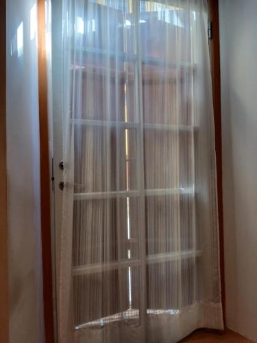 a glass door with white curtains in a room at Parlament in Tallinn