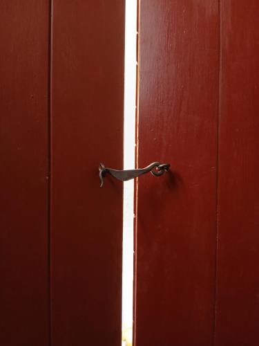an open red door with a metal door handle at Parlament in Tallinn