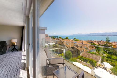 a balcony with a view of the water and buildings at Ambassador Boutique Hotel in Nyon