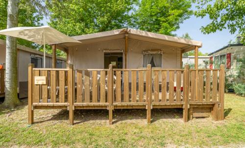 a small shack with an umbrella on a yard at Camping La Scogliera in Santa Cesarea Terme