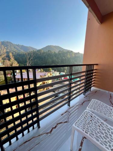 a balcony with a bench and mountains in the background at Hotel Viva La Vida in Dalhousie