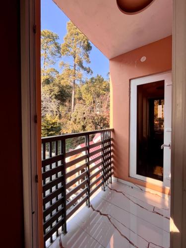 a balcony with a view of the forest at Hotel Viva La Vida in Dalhousie