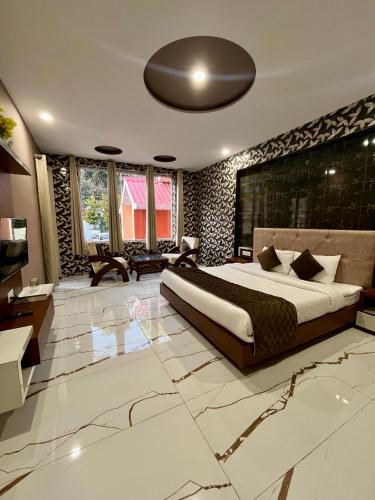 a bedroom with a large bed and a living room at Hotel Viva La Vida in Dalhousie