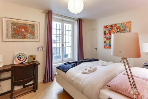 une chambre avec un lit, un bureau et une fenêtre dans l'établissement Marais district - Superb 3 bedroom flatent, à Paris