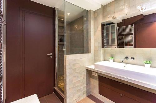 une salle de bain avec un lavabo et une douche dans l'établissement Marais district - Superb 3 bedroom flatent, à Paris